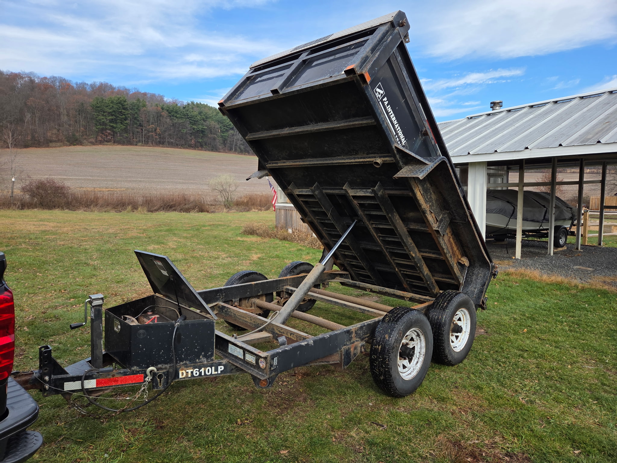 6x10 hydraulic dump trailer tilted up showing dump bed mechanism and equipment ramps